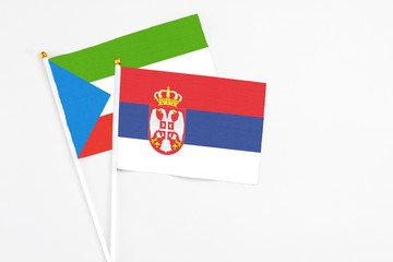 Serbia and Equatorial Guinea stick flags on white background. High quality fabric, miniature national flag. Peaceful global concept.White floor for copy space.