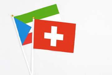 Obraz premium Switzerland and Equatorial Guinea stick flags on white background. High quality fabric, miniature national flag. Peaceful global concept.White floor for copy space.