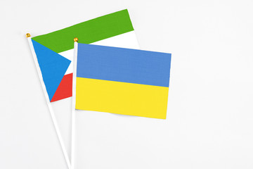Ukraine and Equatorial Guinea stick flags on white background. High quality fabric, miniature national flag. Peaceful global concept.White floor for copy space.