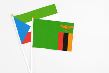 Zambia and Equatorial Guinea stick flags on white background. High quality fabric, miniature national flag. Peaceful global concept.White floor for copy space.