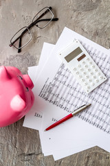Taxes payment concept. Financial documents, piggy bank, calculator on grey background top view