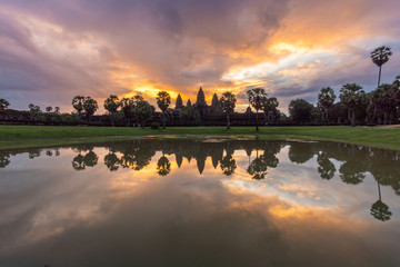 Sunrise view of popular tourist attraction ancient temple complex Angkor Wat with reflected in lake Siem Reap, Cambodia.
