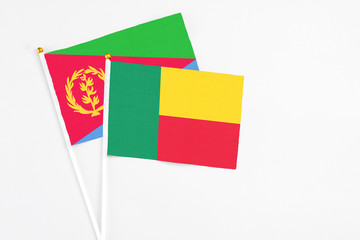 Benin and Eritrea stick flags on white background. High quality fabric, miniature national flag....