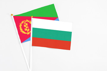 Bulgaria and Eritrea stick flags on white background. High quality fabric, miniature national flag. Peaceful global concept.White floor for copy space.