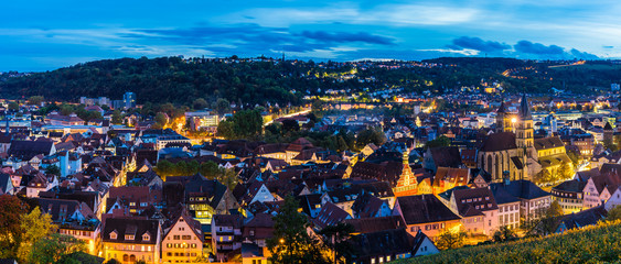 Naklejka premium Germany, XXL panorama aerial view above skyline of medieval city esslingen am neckar, over roofs, houses, church and streets by night in magical twilight atmosphere