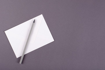Paper envelope with pencil composition on dark background.