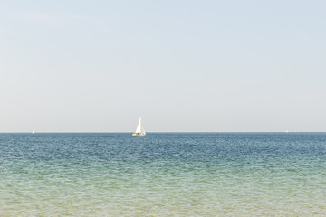 sailing yacht in the sea on the horizon