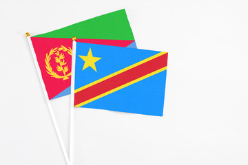 Congo and Eritrea stick flags on white background. High quality fabric, miniature national flag. Peaceful global concept.White floor for copy space.