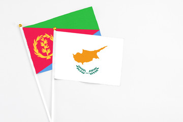 Cyprus and Eritrea stick flags on white background. High quality fabric, miniature national flag. Peaceful global concept.White floor for copy space.