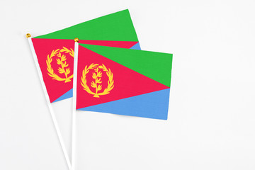 Eritrea and Eritrea stick flags on white background. High quality fabric, miniature national flag. Peaceful global concept.White floor for copy space.