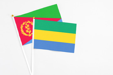 Gabon and Eritrea stick flags on white background. High quality fabric, miniature national flag....