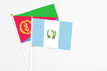 Guatemala and Eritrea stick flags on white background. High quality fabric, miniature national flag. Peaceful global concept.White floor for copy space.