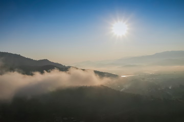 Mountain view morning of soft mist moving around top hill with sea of fog and sun light in the sky background, sunrise at Wat Tha Ton, Tha Ton, Fang, Chiang Mai, Thailand.