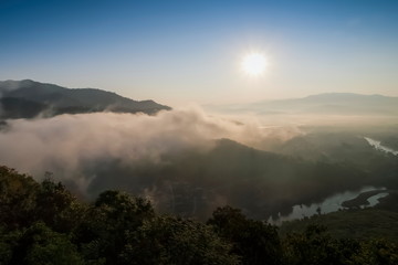 Mountain view morning of soft mist moving around top hill with sea of fog and sun light in the sky background, sunrise at Wat Tha Ton, Tha Ton, Fang, Chiang Mai, Thailand.