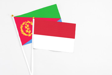 Indonesia and Eritrea stick flags on white background. High quality fabric, miniature national flag. Peaceful global concept.White floor for copy space.