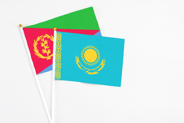 Kazakhstan and Eritrea stick flags on white background. High quality fabric, miniature national flag. Peaceful global concept.White floor for copy space.
