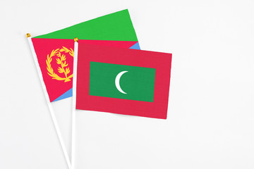 Maldives and Eritrea stick flags on white background. High quality fabric, miniature national flag. Peaceful global concept.White floor for copy space.