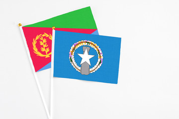 Northern Mariana Islands and Eritrea stick flags on white background. High quality fabric, miniature national flag. Peaceful global concept.White floor for copy space.