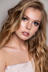 Portrait of a young tender model with ideal skin, professional make-up and a very beautiful natural blond hair.
