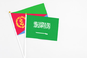 Saudi Arabia and Eritrea stick flags on white background. High quality fabric, miniature national flag. Peaceful global concept.White floor for copy space.