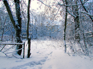 Winter, city landscape. Playground in the yard in the snow. Snowdrifts.