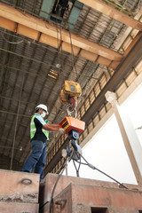 Male engineer controlling electric cable hoist.