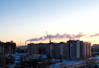 Apartment buildings. Winter Dawn. Smoking chimneys. City landscape.