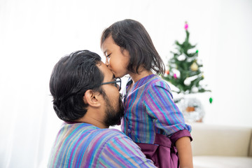 portrait of asian family. father and daughter embrace and kiss each other in christmas day