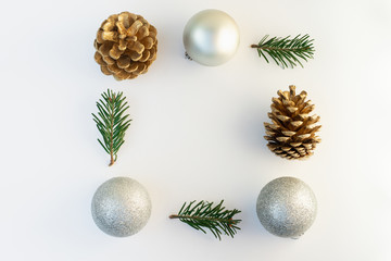 Christmas composition. Frame made of christmas tree branches, silver decorations, bumps on white background. Flat lay, top view, copy space