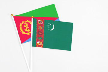 Turkmenistan and Eritrea stick flags on white background. High quality fabric, miniature national flag. Peaceful global concept.White floor for copy space.