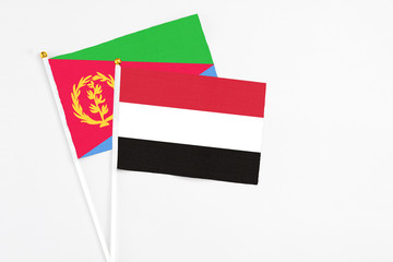 Yemen and Eritrea stick flags on white background. High quality fabric, miniature national flag. Peaceful global concept.White floor for copy space.