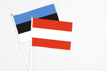 Austria and Estonia stick flags on white background. High quality fabric, miniature national flag. Peaceful global concept.White floor for copy space.