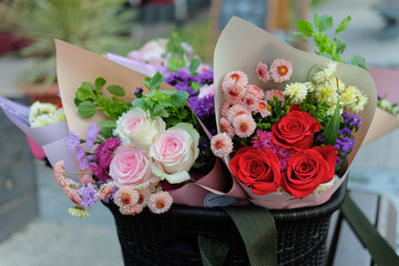 two colored bouquets of flowers in a basket