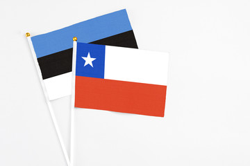 Chile and Estonia stick flags on white background. High quality fabric, miniature national flag. Peaceful global concept.White floor for copy space.
