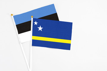 Curacao and Estonia stick flags on white background. High quality fabric, miniature national flag. Peaceful global concept.White floor for copy space.