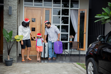 portrait of asian family with suitcase walking in front of their house together before going on holiday vacation