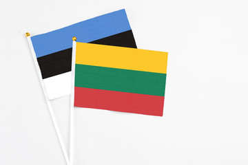 Lithuania and Estonia stick flags on white background. High quality fabric, miniature national flag. Peaceful global concept.White floor for copy space.