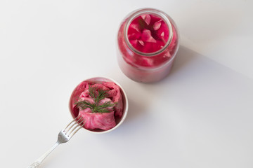 fermented cabbage, with beets on a plate, in a glass jar