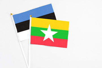 Myanmar and Estonia stick flags on white background. High quality fabric, miniature national flag. Peaceful global concept.White floor for copy space.