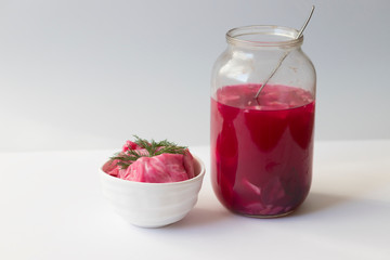fermented cabbage, with beets on a plate, in a glass jar