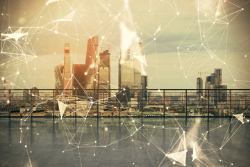 Technology theme hologram with city view from roof background. Double exposure.