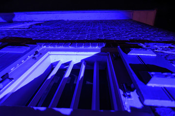 Obraz premium An old-fashioned window with strong metal bars at night, illuminated in blue