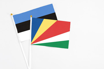 Seychelles and Estonia stick flags on white background. High quality fabric, miniature national flag. Peaceful global concept.White floor for copy space.