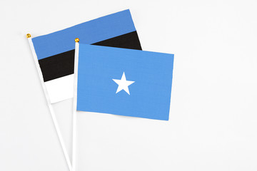 Somalia and Estonia stick flags on white background. High quality fabric, miniature national flag. Peaceful global concept.White floor for copy space.