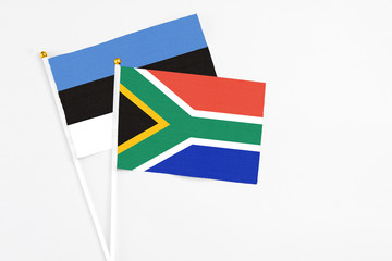 South Africa and Estonia stick flags on white background. High quality fabric, miniature national flag. Peaceful global concept.White floor for copy space.