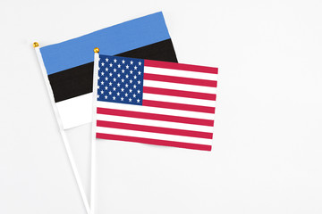 United States and Estonia stick flags on white background. High quality fabric, miniature national flag. Peaceful global concept.White floor for copy space.