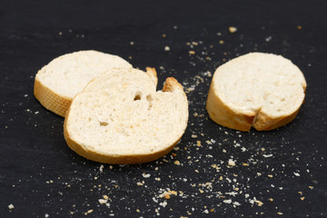 rustic crusty white bread lying on black slate