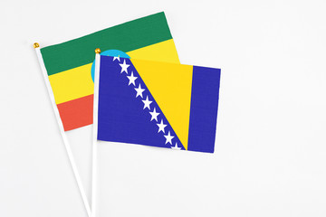 Bosnia Herzegovina and Ethiopia stick flags on white background. High quality fabric, miniature national flag. Peaceful global concept.White floor for copy space.