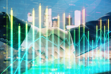 Double exposure of financial chart on cityscape background with two businessmen handshake. Concept of financial analysis and investment opportunities