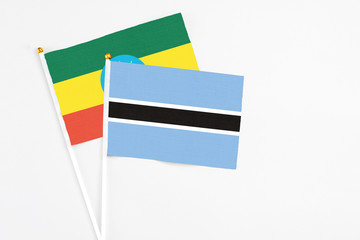 Botswana and Ethiopia stick flags on white background. High quality fabric, miniature national flag. Peaceful global concept.White floor for copy space.